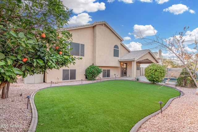 exterior space with a lawn, a tile roof, and stucco siding