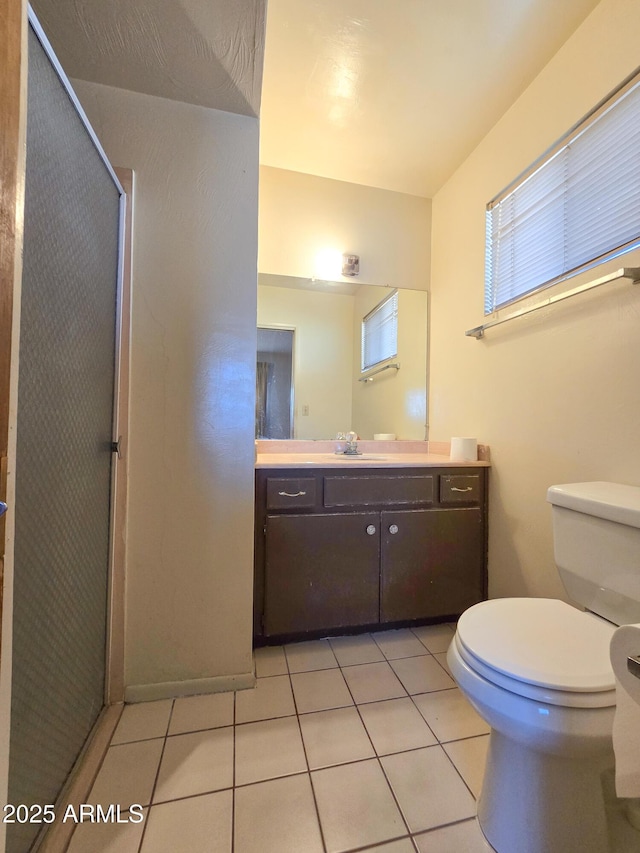 bathroom featuring vanity, toilet, tile patterned floors, and a shower with door