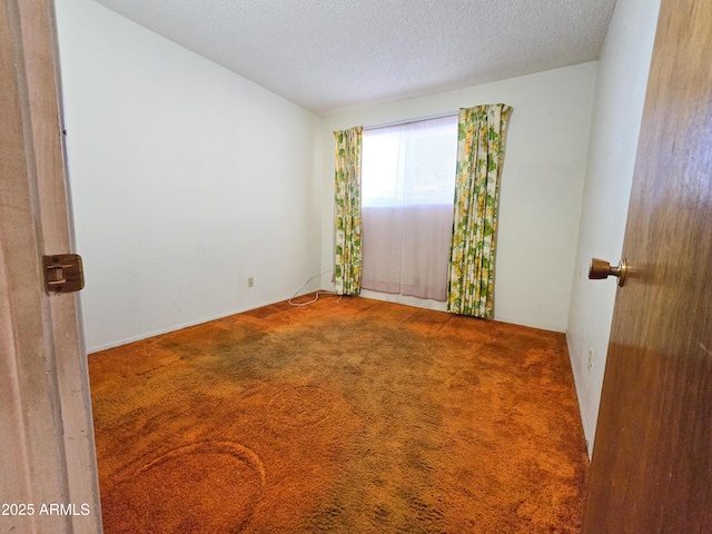 empty room featuring carpet floors and a textured ceiling