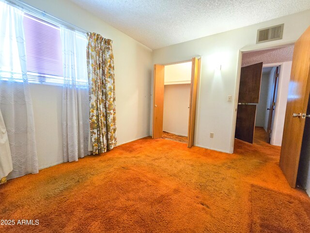 unfurnished bedroom with light colored carpet and a textured ceiling