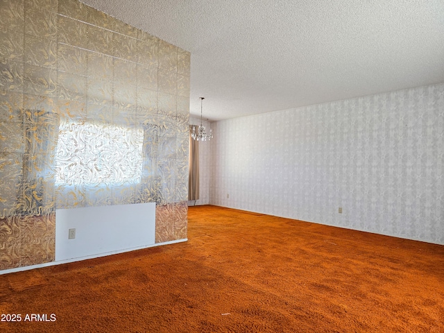 carpeted empty room featuring a textured ceiling