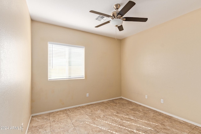 tiled empty room featuring ceiling fan