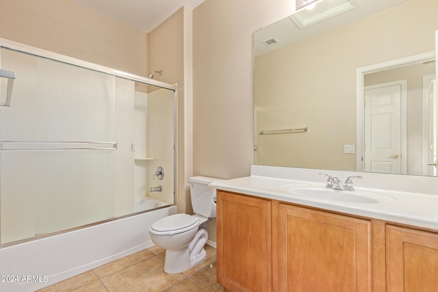 full bathroom featuring shower / bath combination with glass door, vanity, tile patterned flooring, and toilet