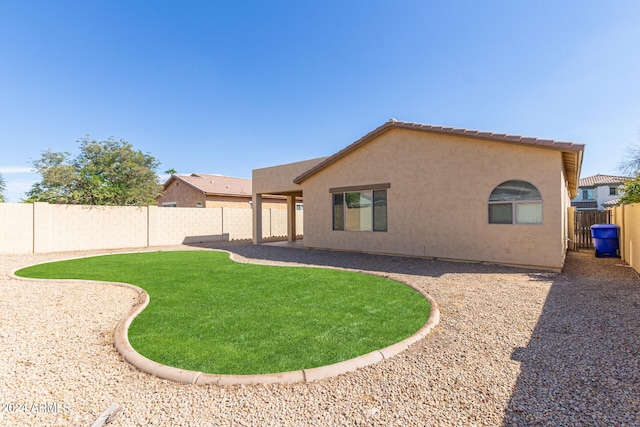 rear view of property with a lawn and a patio area