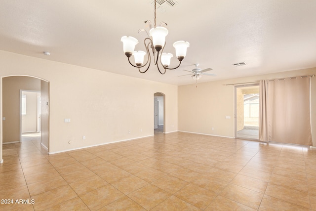 tiled spare room featuring ceiling fan with notable chandelier