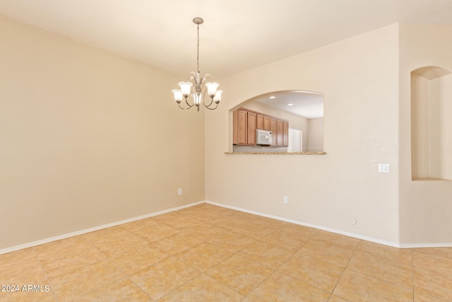 unfurnished room featuring a chandelier and light tile patterned floors