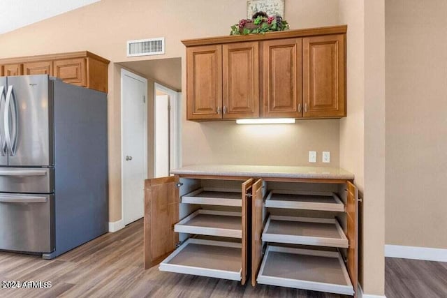 kitchen with hardwood / wood-style flooring and stainless steel refrigerator