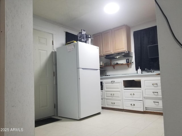1226 N Mckinley Ave, Ajo, AZ 85321 - kitchen with freestanding refrigerator, light countertops, white cabinets, and under cabinet range hood