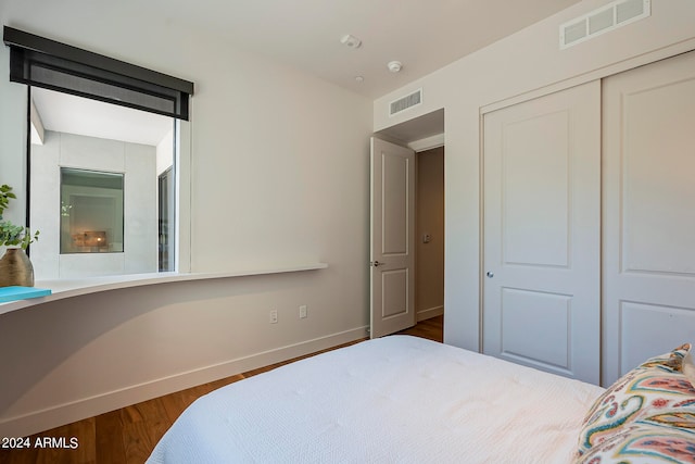 bedroom featuring wood-type flooring and a closet