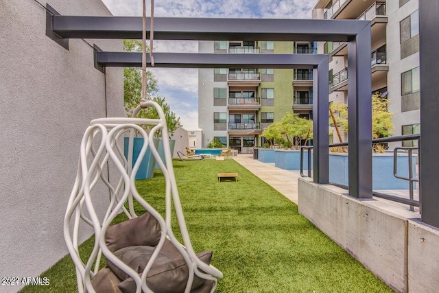 view of home's community with a pool and a lawn