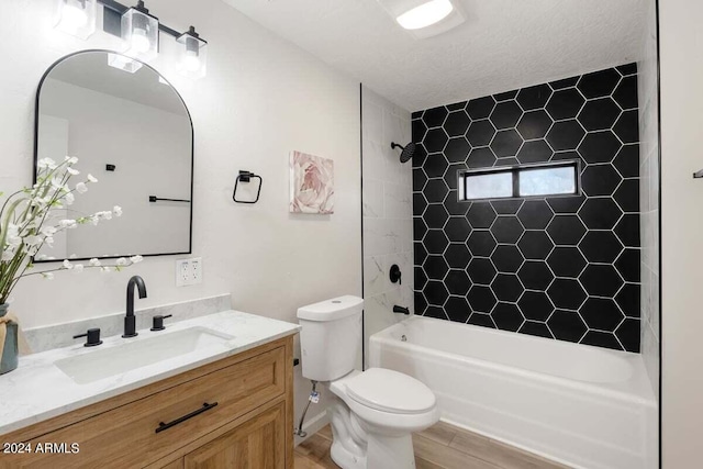 full bathroom featuring vanity, toilet, tiled shower / bath combo, a textured ceiling, and hardwood / wood-style floors