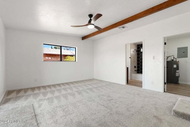 unfurnished room featuring ceiling fan, beam ceiling, a textured ceiling, light colored carpet, and water heater