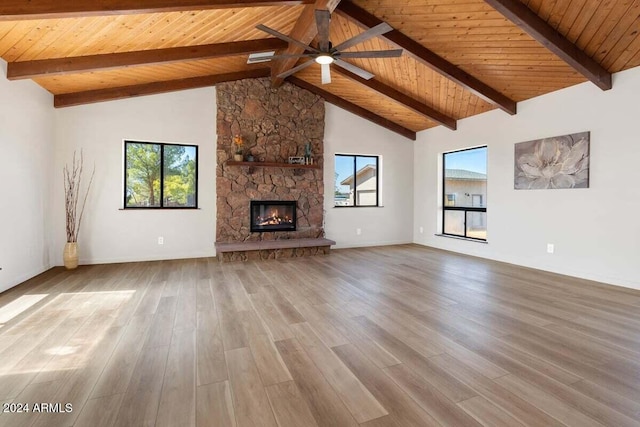 unfurnished living room with a fireplace, plenty of natural light, wooden ceiling, and light hardwood / wood-style floors