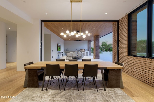 7341 E Sunnyside Dr, Scottsdale, AZ 85260 - dining area with a chandelier, expansive windows, wood finished floors, and brick wall