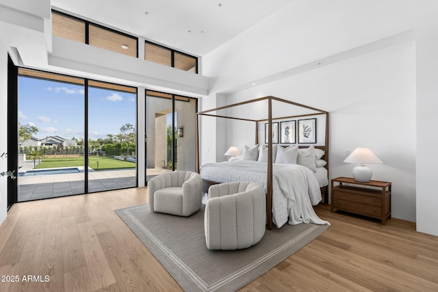 7341 E Sunnyside Dr, Scottsdale, AZ 85260 - bedroom with access to exterior, wood finished floors, and a high ceiling