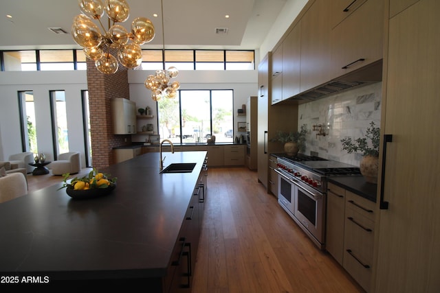 7341 E Sunnyside Dr, Scottsdale, AZ 85260 - kitchen featuring premium appliances, a chandelier, a sink, dark countertops, and a large island