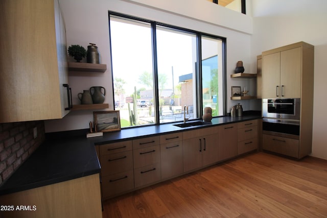 7341 E Sunnyside Dr, Scottsdale, AZ 85260 - kitchen featuring open shelves, a sink, stainless steel oven, dark countertops, and light wood finished floors