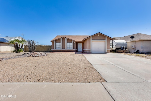 view of front facade with stucco siding, an attached garage, concrete driveway, and fence