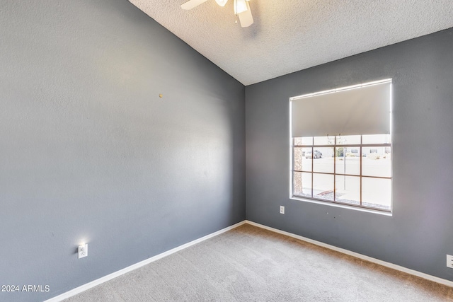 spare room featuring baseboards, carpet, lofted ceiling, a textured ceiling, and a ceiling fan