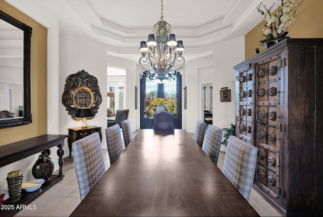 tiled dining room with a raised ceiling and an inviting chandelier