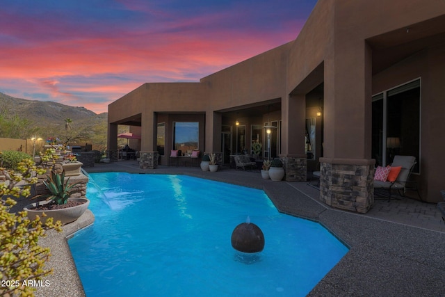 pool with a patio area and a mountain view