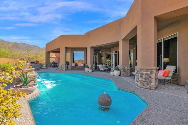 view of pool with ceiling fan, a mountain view, a fenced in pool, and a patio