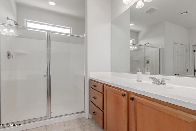 bathroom featuring tile patterned flooring, vanity, visible vents, and a shower stall