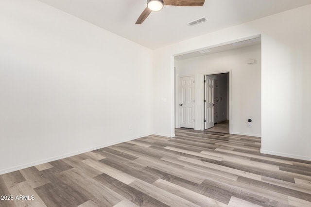 spare room with visible vents, ceiling fan, baseboards, and wood finished floors