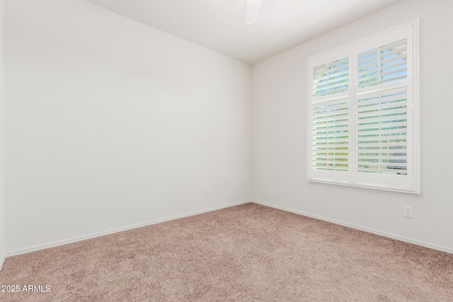 spare room featuring carpet floors and baseboards