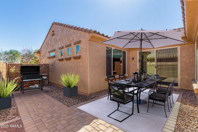 view of patio featuring outdoor dining area and fence