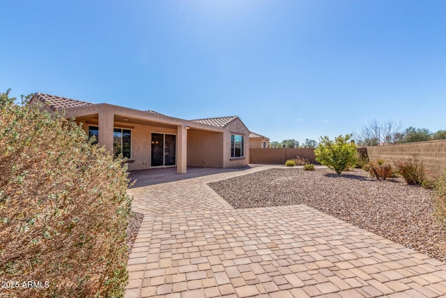 back of house featuring a patio area, a fenced backyard, and stucco siding