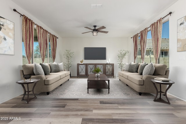 living area featuring plenty of natural light, visible vents, and wood finished floors