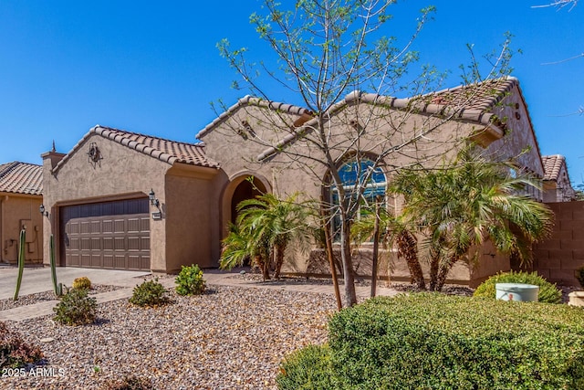 mediterranean / spanish-style home featuring concrete driveway, an attached garage, a tile roof, and stucco siding