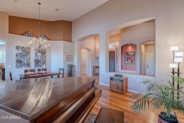 interior space featuring high vaulted ceiling, an inviting chandelier, and light hardwood / wood-style floors