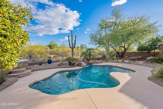 view of swimming pool with pool water feature and a patio