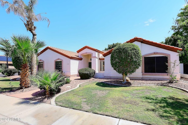 mediterranean / spanish home with a front yard