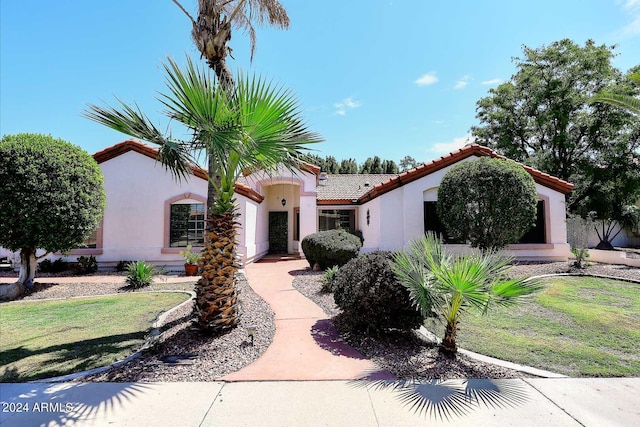 mediterranean / spanish-style house featuring a front yard