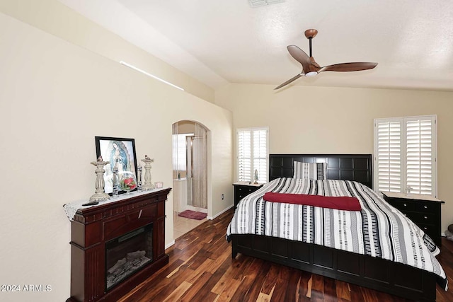 bedroom featuring lofted ceiling, dark wood-type flooring, ceiling fan, and ensuite bathroom