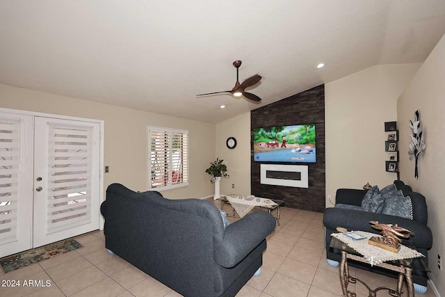 living room featuring a large fireplace, ceiling fan, light tile patterned flooring, and vaulted ceiling