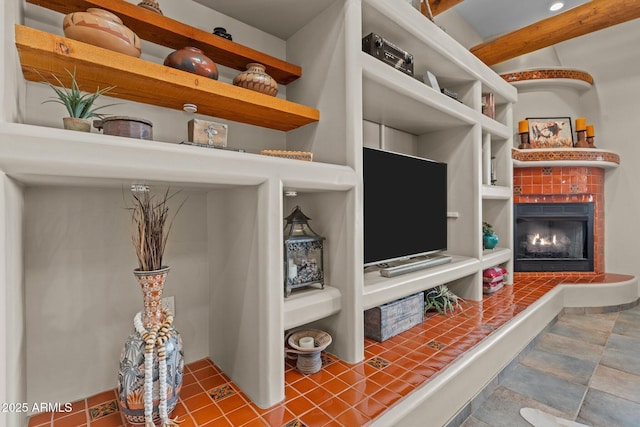 living area with beamed ceiling and a fireplace