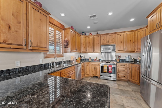 kitchen with visible vents, dark stone counters, recessed lighting, a sink, and appliances with stainless steel finishes