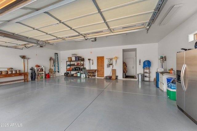 garage featuring a garage door opener and stainless steel fridge with ice dispenser