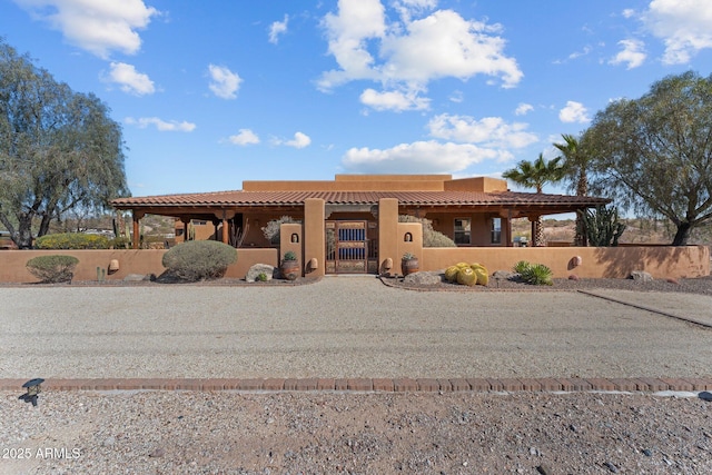 view of front of house with a gate, a fenced front yard, and stucco siding