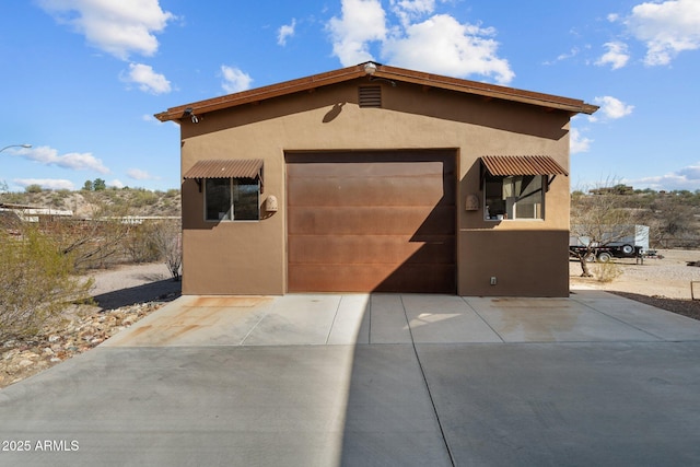 view of front of home with stucco siding, a garage, and concrete driveway