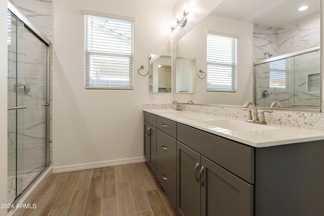 bathroom featuring a stall shower, a sink, and wood finish floors