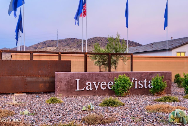 community sign featuring fence and a mountain view