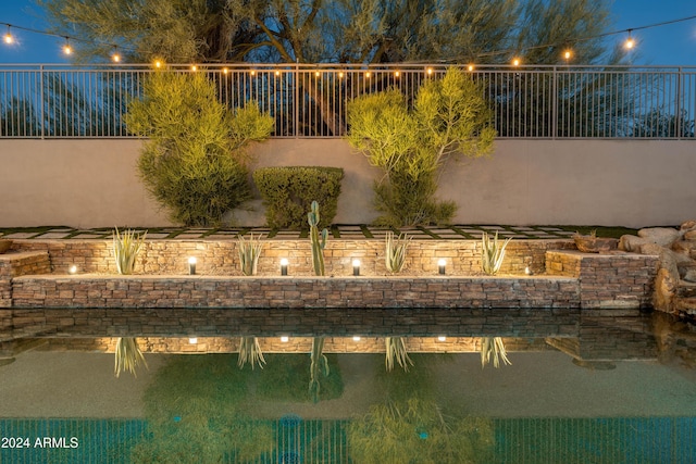 view of pool at twilight