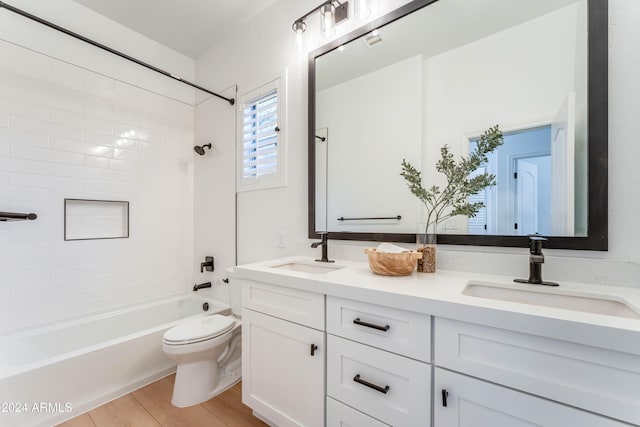 full bathroom featuring toilet, hardwood / wood-style floors, vanity, and tiled shower / bath