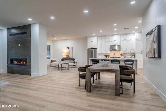 dining area featuring a fireplace and light hardwood / wood-style floors