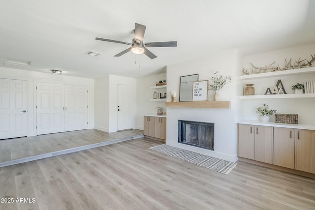 2337 E Contessa St, Mesa, AZ 85213 - unfurnished living room with light wood finished floors, a ceiling fan, and a fireplace